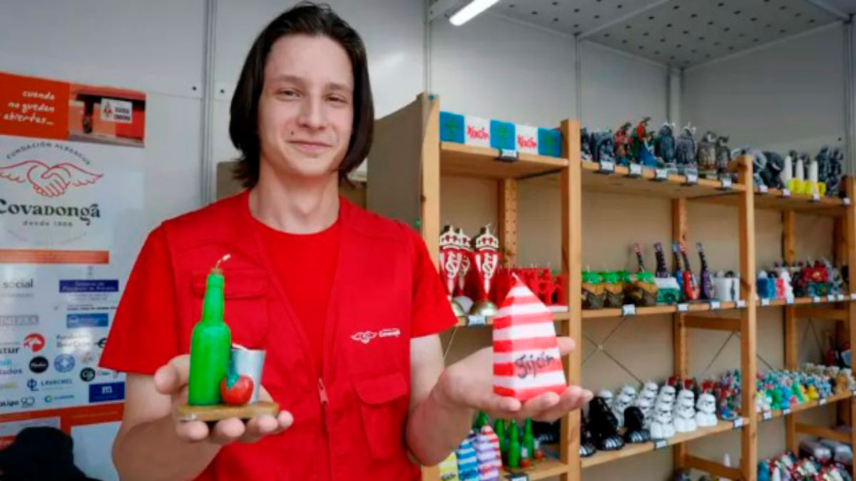 Roman Maksimov, voluntario del Albergue, con dos de las velas más vendidas en el stand, ayer, en FIDMA
